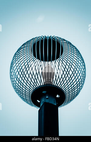 Beautiful light post with soft blue hue and metal globe design. Stock Photo