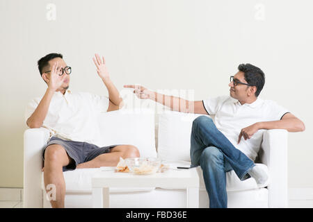 Men arguing. Two young male friend having argument at home. Multiracial people friendship. Stock Photo