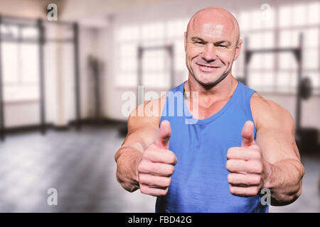 Composite image of smiling healthy man showing thumbs up Stock Photo