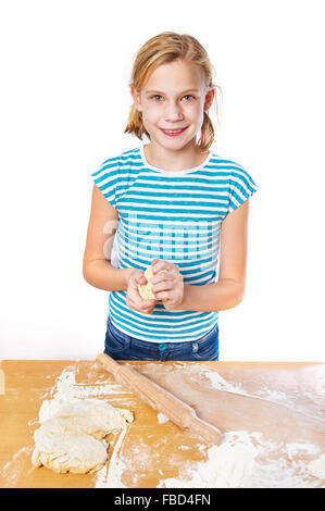 Girl kneads the dough for the pie on the kitchen table isolated Stock Photo