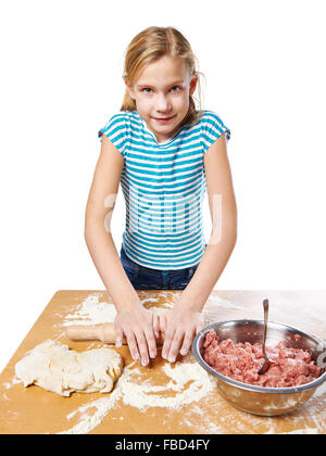 Girl kneads dough on kitchen table isolated Stock Photo