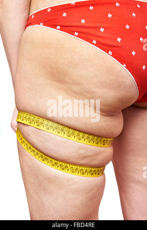 Fat woman measuring her thigh leg tape measure Stock Photo