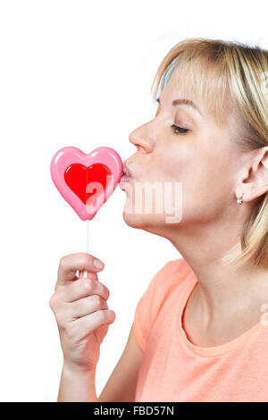 Happy girl kissing heart shaped lollipop on white isolated Stock Photo