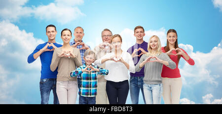 people showing heart hand sign over sky and clouds Stock Photo