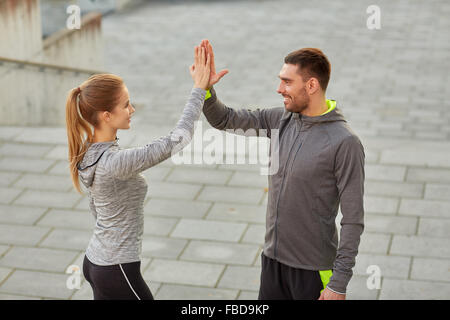 happy couple giving high five outdoors Stock Photo