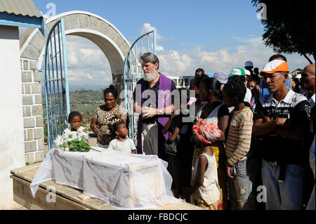 MADAGASCAR Antananarivo, catholic priest Per Pedro Opeka has build Akamasoa a social community project with housing schemes, health units and schools for the poorest of Tana, burial of dead child / MADAGASKAR Pater Pedro Opeka hat die Gemeinde Akamasoa , auf madagassisch 'gute Freunde' , mit Muellsammlern, Bettlern und Sozialschwachen auf einem Huegel bei Antananarivo erbaut, Teil des Projektes sind Hausbau, Schulen, Krankenhaeuser und Beschaeftigung, Beerdigung eines verstorbenen Kindes Stock Photo