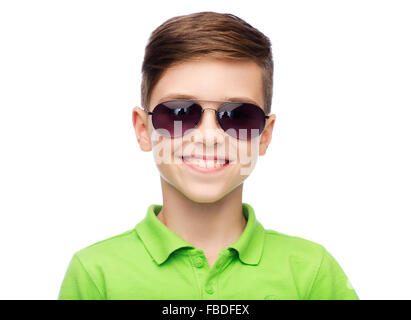 smiling teenage boy in sunglasses taking notes and looking away