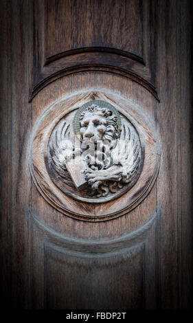 The winged lion of St. Mark, the symbol of the Venetian Republic, engraved on a portal of an old church. Stock Photo