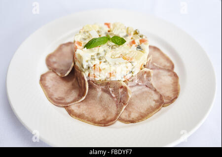 Olivier with beef tongue on white plate studio shot Stock Photo