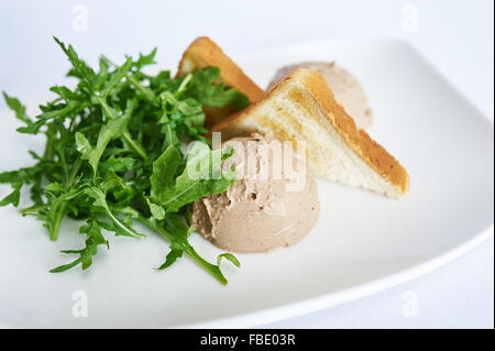 Chicken liver pate on white plate studio shot Stock Photo