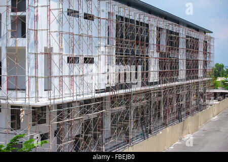 Commercial building construction work in progress with scaffolding setup. Stock Photo