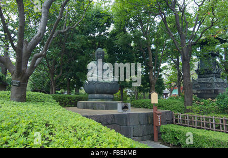 Tokyo Japan quiet area with Buddha statue at Sensoji Temple at Tokyo's oldest temple with green hedges and peaceful scene Stock Photo