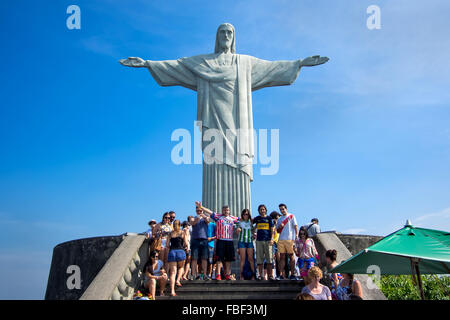 Tourists posing in front of famous Christ the Redeemer statue atop the Corcovado mountain in Rio de Janeiro, Brazil. Stock Photo