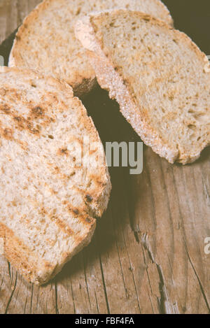 Some sliced bread during the preparation of the typical italian's starter: 'Bruschetta'. Toned image Stock Photo