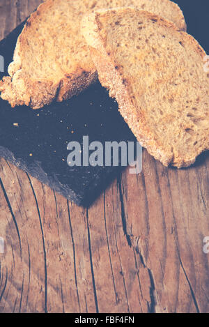 Some sliced bread during the preparation of the typical italian's starter: 'Bruschetta'. Toned image Stock Photo