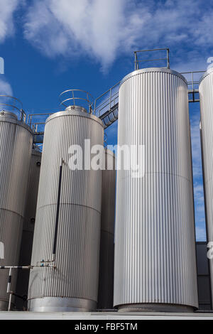 Giant industrial tanks on the bright blue sky background Stock Photo