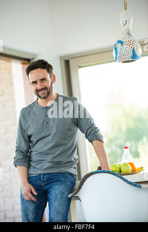 Man sitting on kitchen table Stock Photo