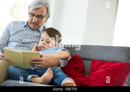 Grandfather and grandson reading a book Stock Photo