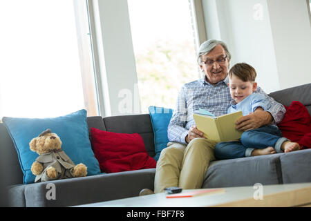 Grandfather and grandson reading a book Stock Photo