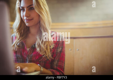Smiling female student using laptop Stock Photo