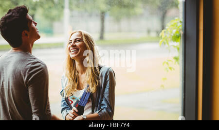 Smiling female student talking to a friend Stock Photo