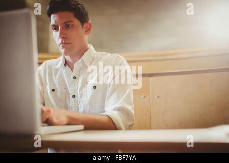 Concentrated male student using laptop Stock Photo