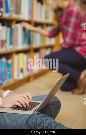 Cropped image of student using laptop on floor Stock Photo