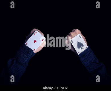 two fists with hearts and spades aces in the hole Stock Photo