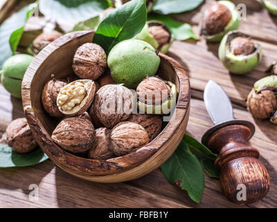 Walnuts in the wooden bowl on the table. Stock Photo