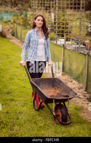 Woman pushing a wheelbarrow Stock Photo