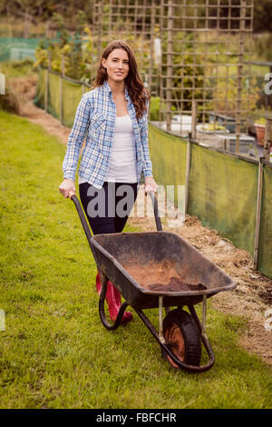Portrait woman pushing wheelbarrow garden Stock Photo - Alamy
