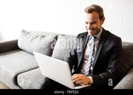 Smiling businessman using laptop Stock Photo