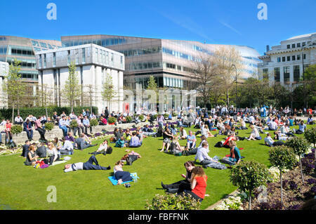 Office workers and tourists relaxing in the sunshine at Festival Gardens by St Paul's Cathedral, City of London, UK Stock Photo