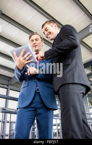Businessmen talking together while looking tablet Stock Photo