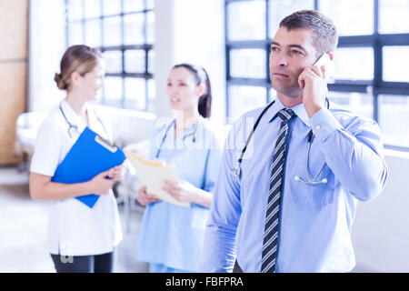 Serious male doctor using smartphone Stock Photo