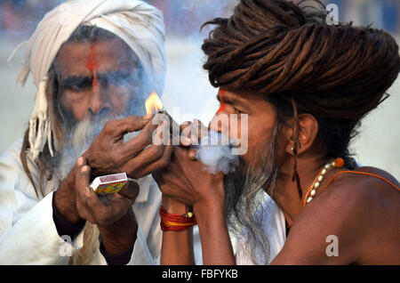 Allahabad, Indian state of Uttar Pradesh. 15th Jan, 2016. A sadhu smokes pipe during Makar Sankranti in Allahabad, northern Indian state of Uttar Pradesh, Jan. 15, 2016. Makar Sankranti, which marks transition of the sun into the zodiacal sign of Makara (Capricorn) on its celestial path, is a Hindus festival celebrated in almost all parts of India. Credit:  Stringer/Xinhua/Alamy Live News Stock Photo