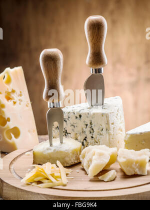Variety of cheeses on a wooden board. Stock Photo