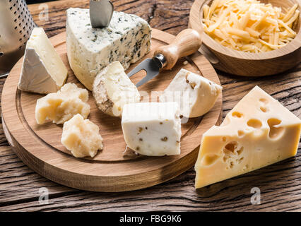 Variety of cheeses on a wooden board. Stock Photo