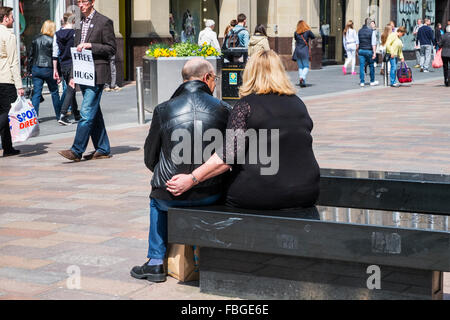 overweight loving couple sitting bench street uk Stock Photo