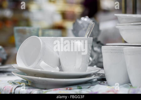 white cups with spoons on plates Stock Photo