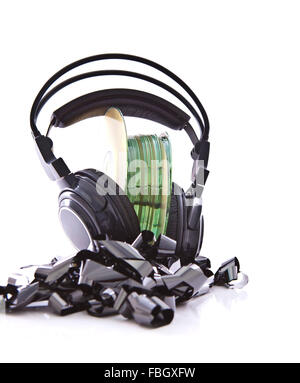 Stack of CDs with HI-Fi headphones on vintage reel of audio tape on white background Stock Photo