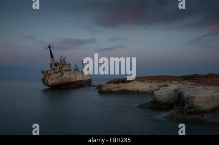 Abandoned Ship on the rocky coast  with beautiful blue and orange morning colors at Paphos area in Cyprus Stock Photo