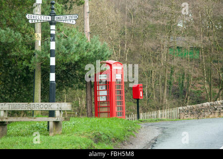 Red telephone box and red post box with finger post road sign at the Cheshire village of Timbersbrooke near Congleton Cheshire