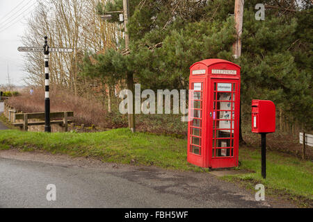 Red telephone box and red post box with finger post road sign at the Cheshire village of Timbersbrooke near Congleton Cheshire