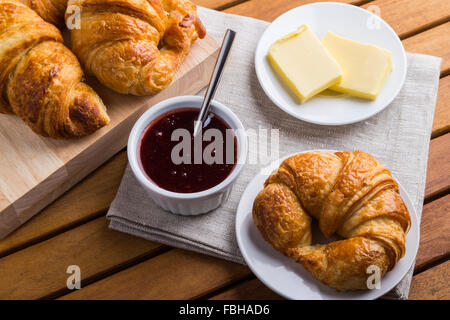 Croissants jam and butter on wooden table Stock Photo