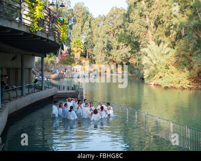 Christian group praying inside the water at the Yardenit baptismal site in Jordan river Stock Photo