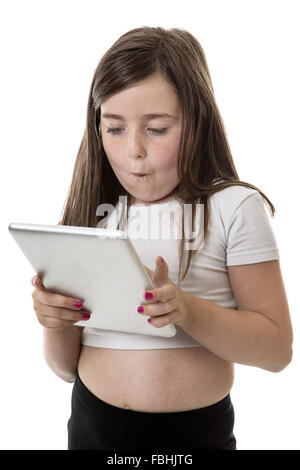 Pretty young girl is enjoying playing on her tablet computer Stock Photo