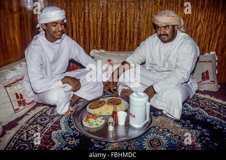 Nizwa, Oman.  Sitting on the floor in an Omani restaurant for lunch of fish, rice, and salad. Stock Photo