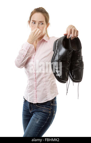 woman holding up a pair of men smelly shoes Stock Photo