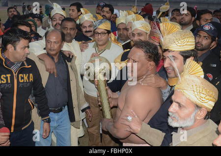 Lahore, Pakistan. 16th Jan, 2016. A wrestler champion holding his award with people taking a photo with him. Pakistani traditional wrestlers (Pehalwans) compete during RUSTAM-E-ZAMAN GAMA PEHALWAN DANGAL. © Rana Sajid Hussain/Alamy Live News Stock Photo